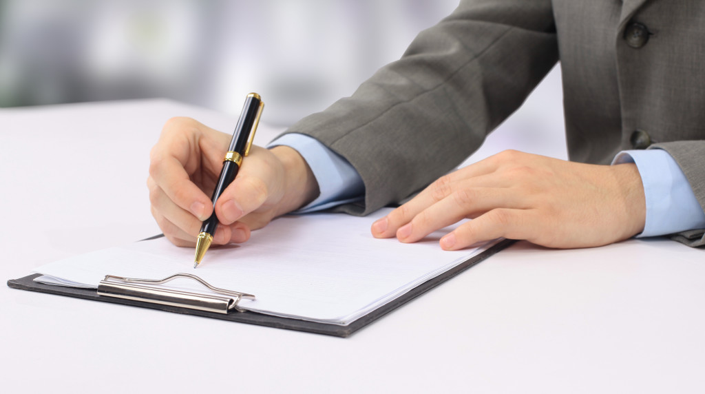 Close-up picture of hands writing in the business dairy.